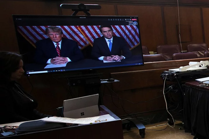 Frustrated Trump waves hands in virtual court appearance as criminal trial set during 2024 elections