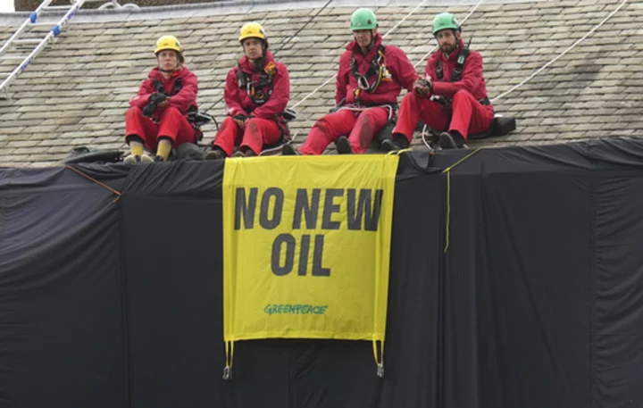 Greenpeace demonstrators drape UK prime minister's house in black to protest oil expansion