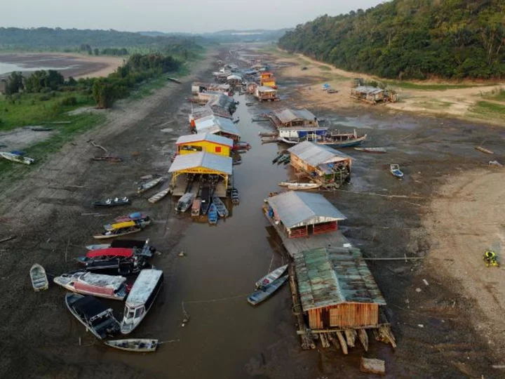 A floating village is stranded on a dry lakebed as extreme drought grips the Amazon