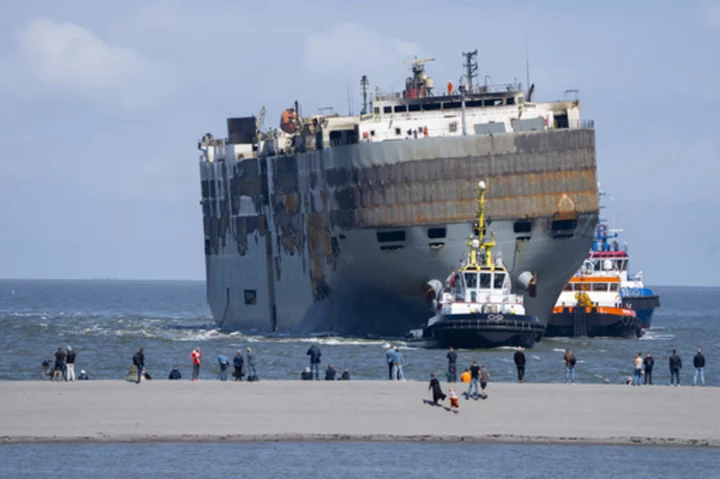 A car-carrying ship that burned for a week on the North Sea is towed to a Dutch port for salvaging