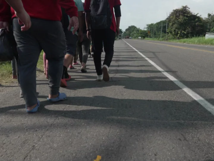 Families weave through long grass to dodge migration checkpoints