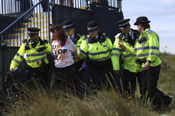 Environmental activists disrupt play at British Open by throwing orange substance on 17th green